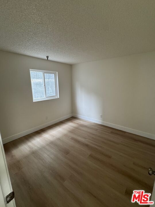 428 South Grand View Street Los Angeles, CA 90057 - Photo 23 of 29 an empty room with wooden floor and windows