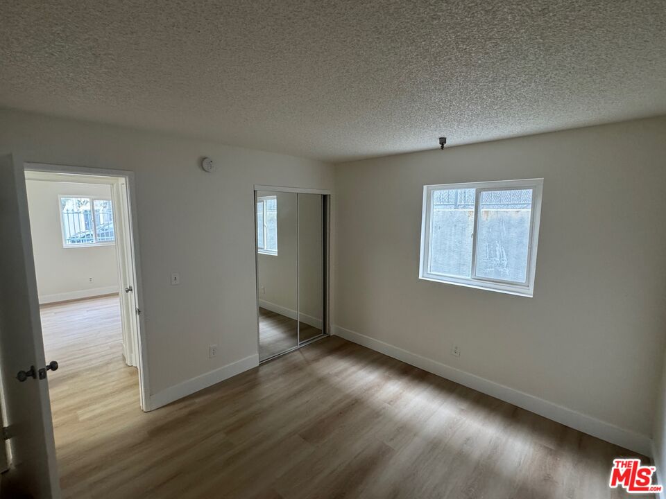 428 South Grand View Street Los Angeles, CA 90057 - Photo 24 of 29 a view of an empty room with wooden floor and a window