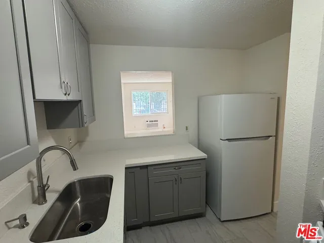 a kitchen with a refrigerator sink and cabinets