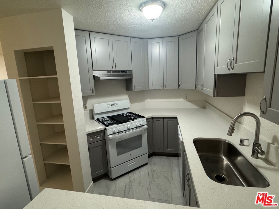 428 South Grand View Street Los Angeles, CA 90057 - Photo 8 of 29 a kitchen with a sink a stove and refrigerator