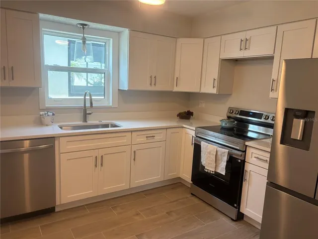 a kitchen with stainless steel appliances granite countertop a refrigerator sink and cabinets