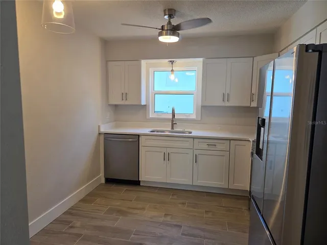 a kitchen with cabinets appliances a sink and a window
