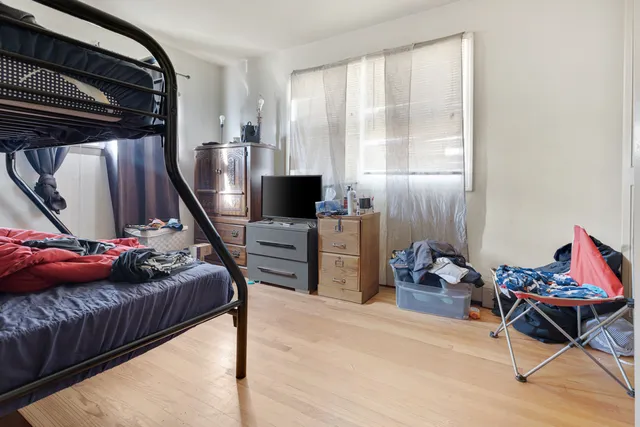a bedroom with furniture and a air conditioner vent