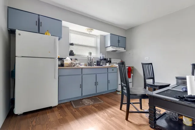 a kitchen with appliances a refrigerator and a stove top open