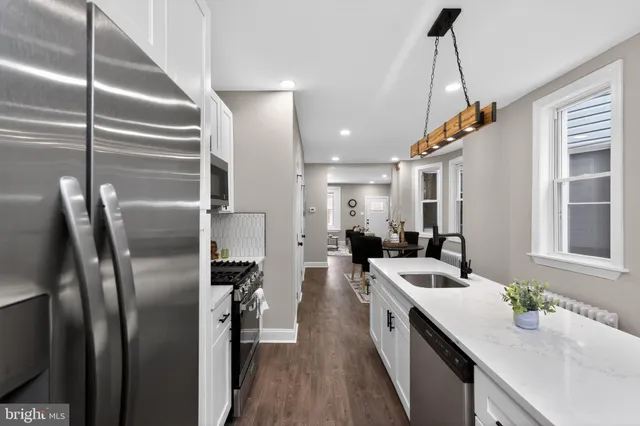 a kitchen with stainless steel appliances granite countertop a sink a stove and a refrigerator