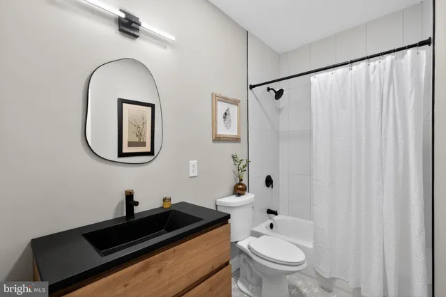 a bathroom with a granite countertop sink a toilet and a mirror