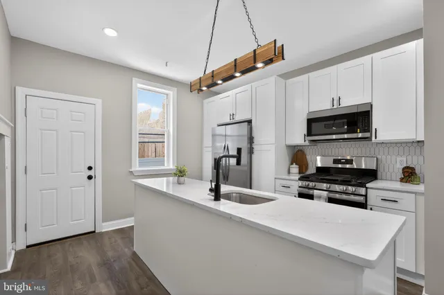 a kitchen with stainless steel appliances a stove sink microwave and cabinets