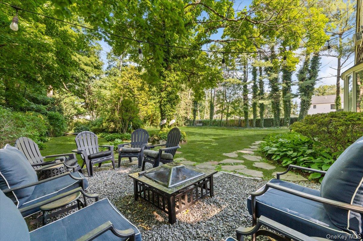 10 Rancher Place Huntington, NY 11743 - Photo 39 of 44 Spacious backyard featuring a stone paver path, mature trees, and string lighting