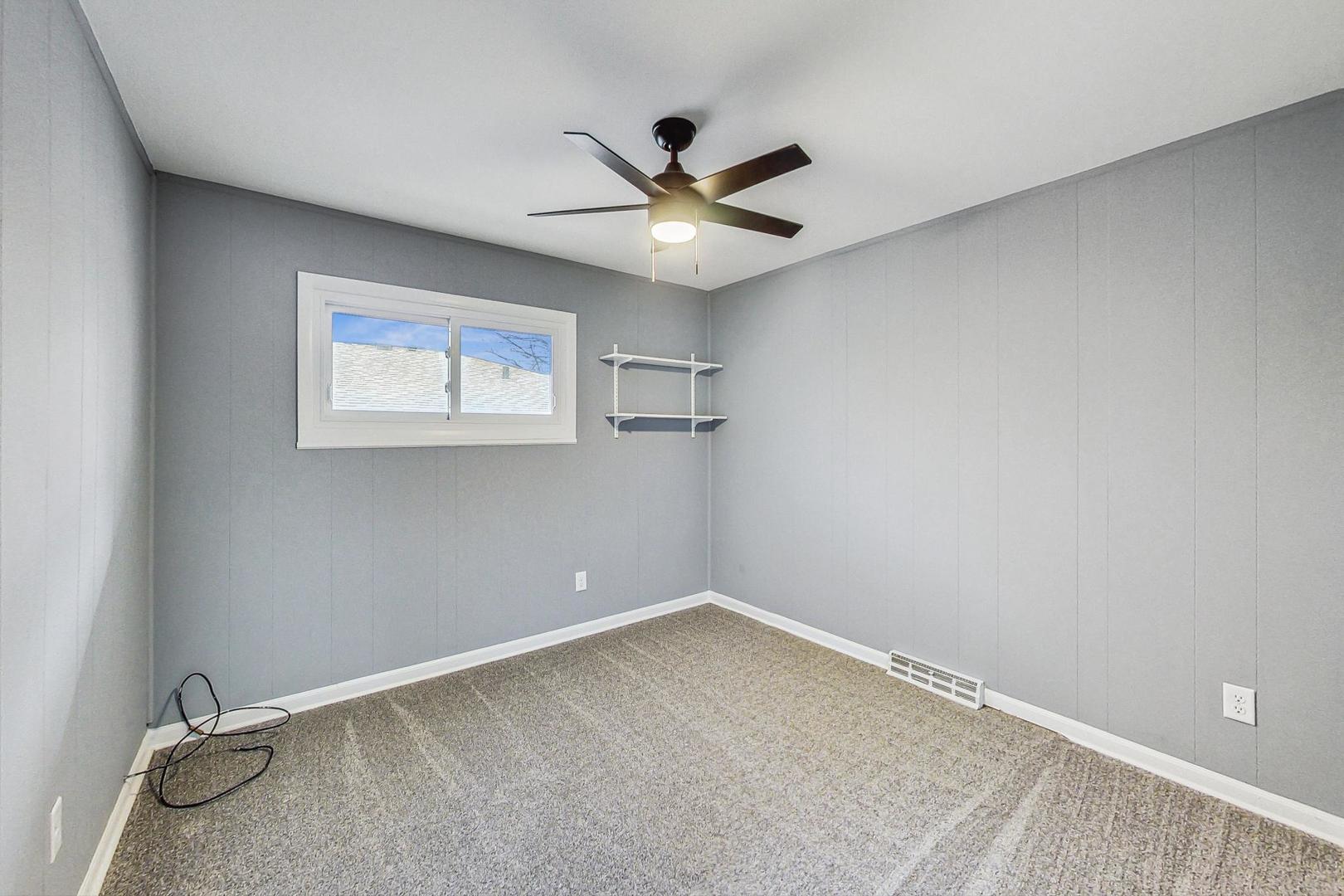 830 Russell Avenue Winthrop Harbor, IL 60096 - Photo 13 of 33 an empty room with a window and a ceiling fan