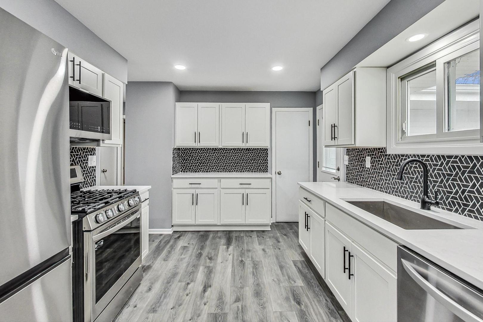 830 Russell Avenue Winthrop Harbor, IL 60096 - Photo 7 of 33 a kitchen with granite countertop a stove sink and cabinets