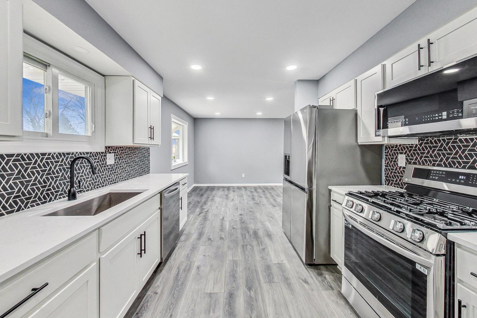 830 Russell Avenue Winthrop Harbor, IL 60096 - Photo 9 of 33 a kitchen with stainless steel appliances granite countertop a stove and a sink