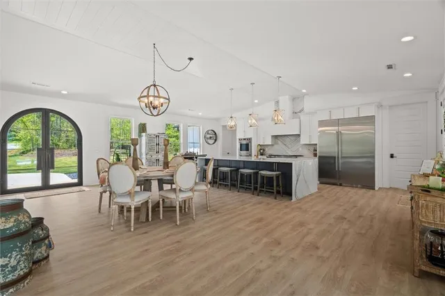 a view of a dining room with furniture a chandelier and wooden floor