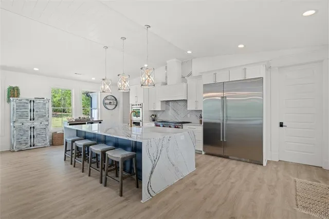 a large white kitchen with lots of counter space and chandelier