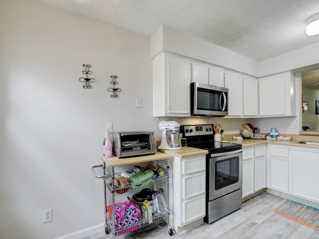 6022 Indrio Road, Unit G3 Fort Pierce, FL 34951 - Photo 18 of 36 a kitchen with microwave a stove and cabinets