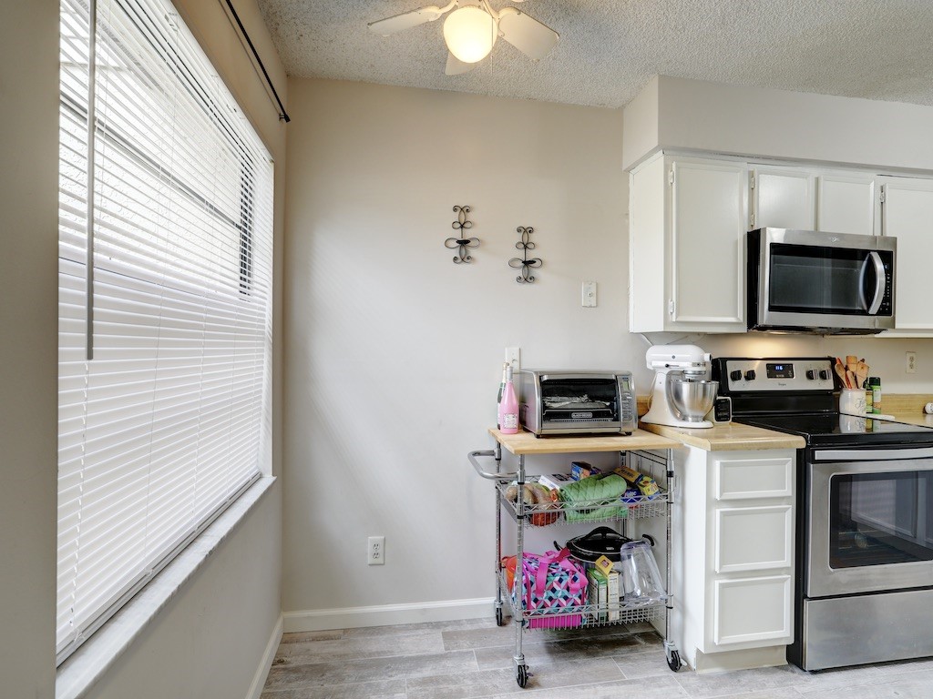 6022 Indrio Road, Unit G3 Fort Pierce, FL 34951 - Photo 24 of 36 a kitchen with stainless steel appliances granite countertop a stove a microwave and a window