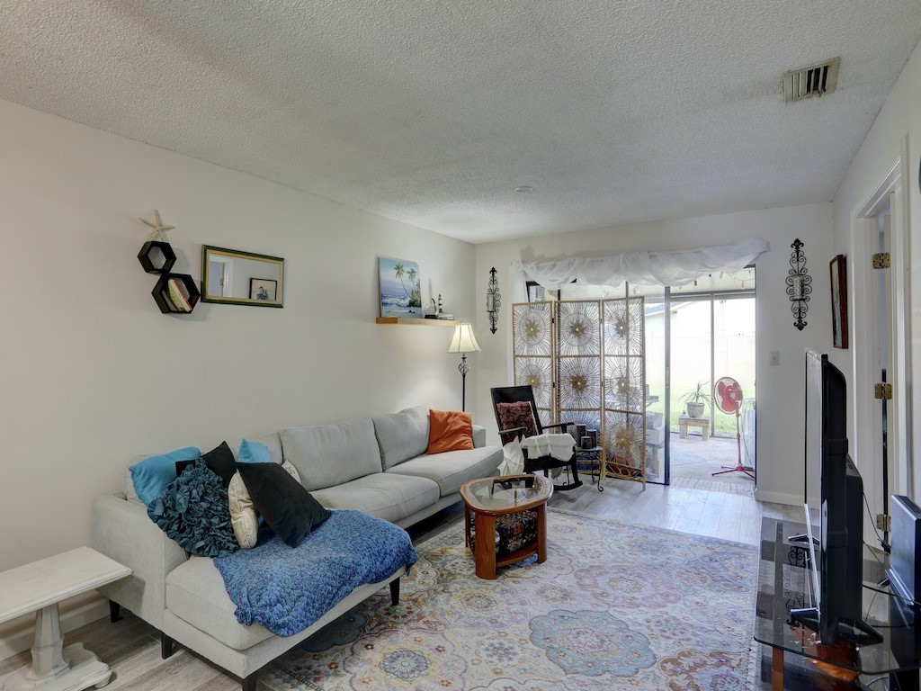 6022 Indrio Road, Unit G3 Fort Pierce, FL 34951 - Photo 10 of 36 a living room with furniture large window and a flat screen tv