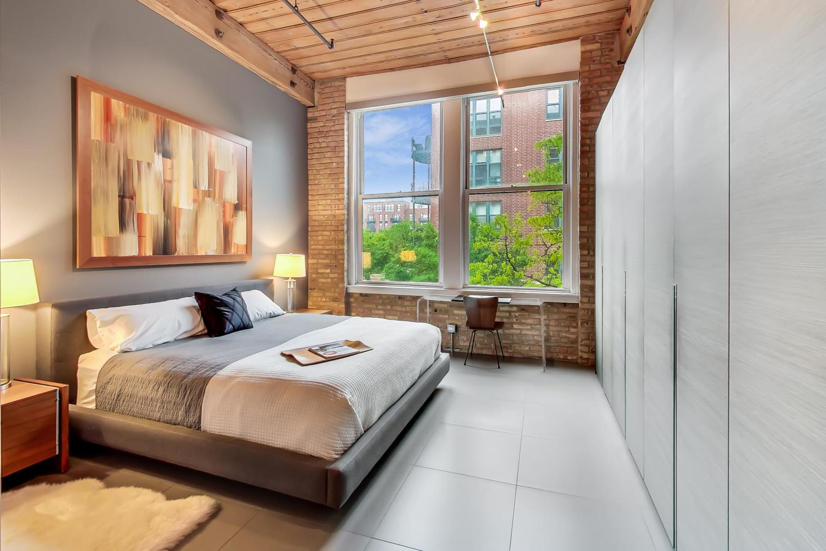 1327 West Washington Boulevard, Unit 2H Chicago, IL 60607 - Photo 12 of 31 a bedroom with a bed and a large window