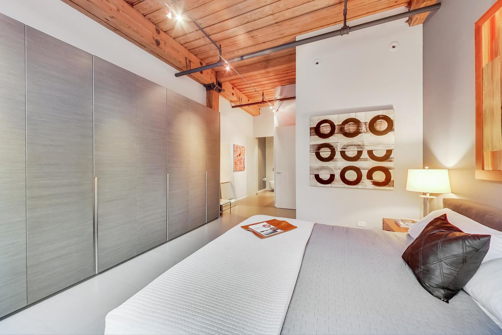 1327 West Washington Boulevard, Unit 2H Chicago, IL 60607 - Photo 14 of 31 a bedroom with a bed and a chair