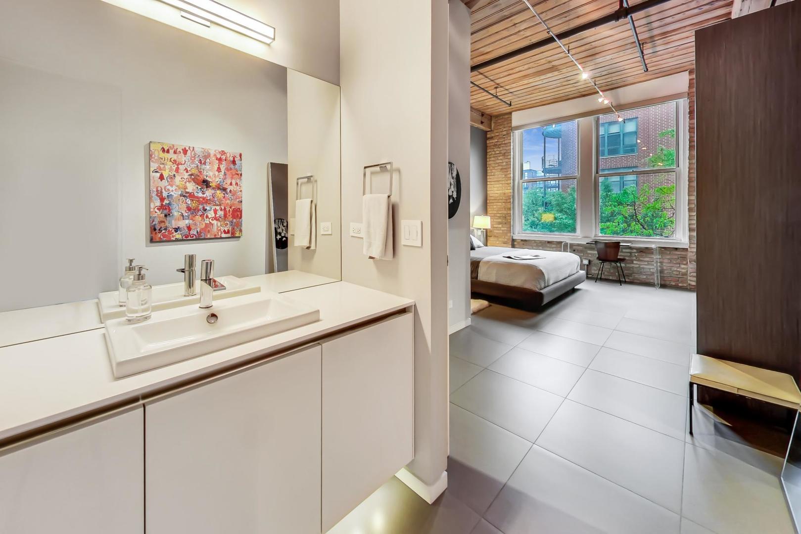 1327 West Washington Boulevard, Unit 2H Chicago, IL 60607 - Photo 16 of 31 a en suite bathroom with a sink and a large mirror