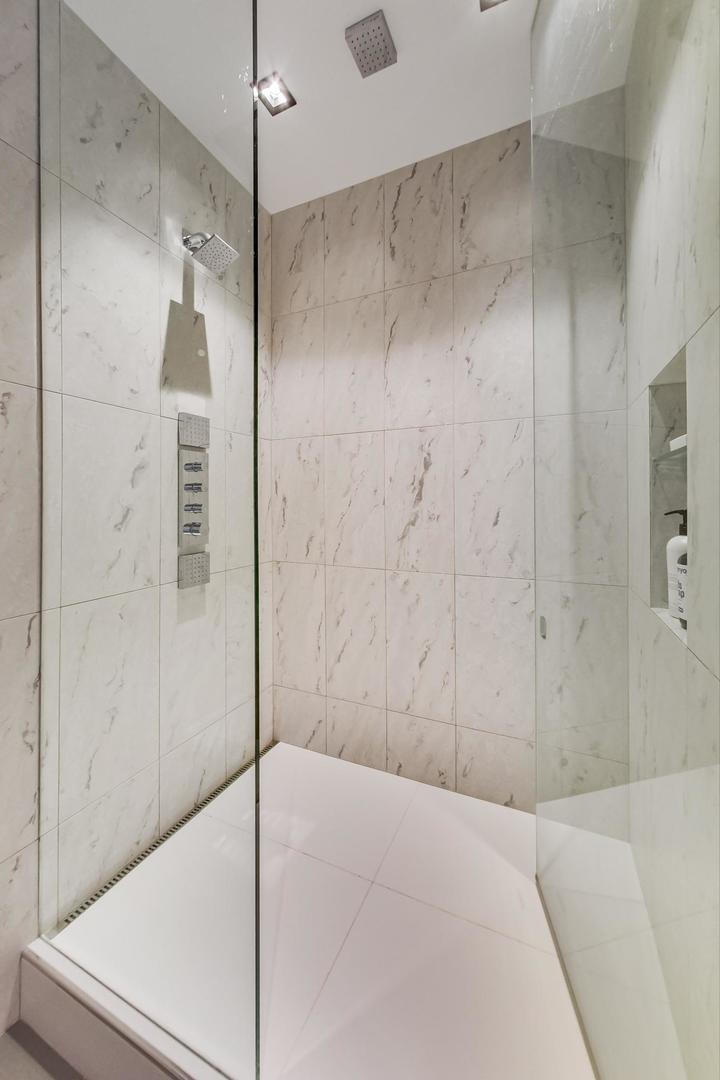 1327 West Washington Boulevard, Unit 2H Chicago, IL 60607 - Photo 17 of 31 a bathroom with a shower and a glass door