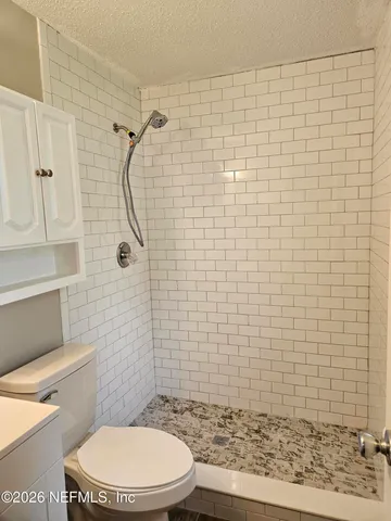 a bathroom with a toilet and a shower