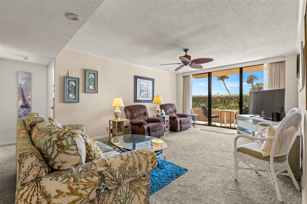 1 Key Capri, Unit 104E Treasure Island, FL 33706 - Photo 13 of 45 a living room with furniture large windows and a flat screen tv