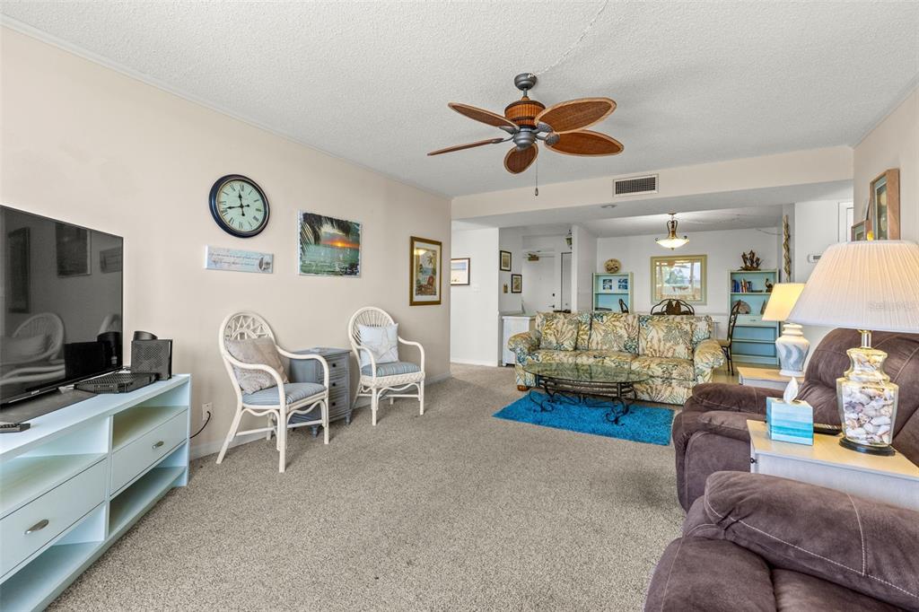1 Key Capri, Unit 104E Treasure Island, FL 33706 - Photo 15 of 45 a living room with furniture and a flat screen tv