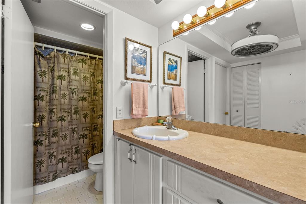 1 Key Capri, Unit 104E Treasure Island, FL 33706 - Photo 20 of 45 a bathroom with a granite countertop sink a toilet and shower