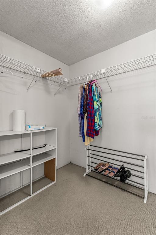 1 Key Capri, Unit 104E Treasure Island, FL 33706 - Photo 21 of 45 a view of walk in closet with clothes and shoes
