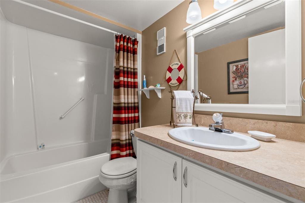 1 Key Capri, Unit 104E Treasure Island, FL 33706 - Photo 22 of 45 a bathroom with a sink vanity mirror and toilet