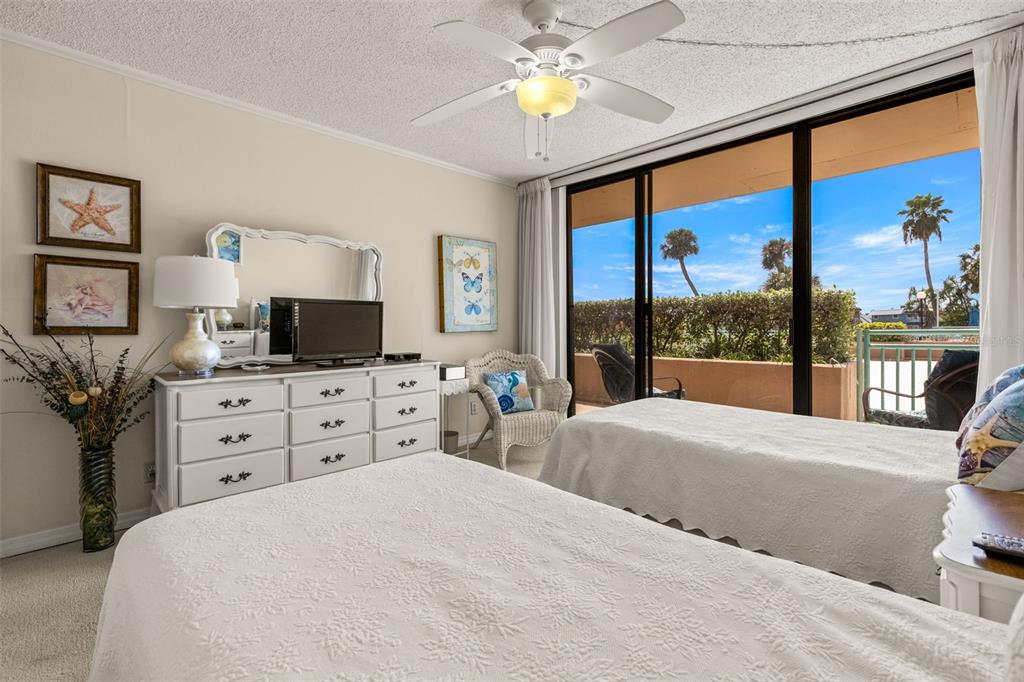 1 Key Capri, Unit 104E Treasure Island, FL 33706 - Photo 25 of 45 a bedroom with a bed and a flat screen tv