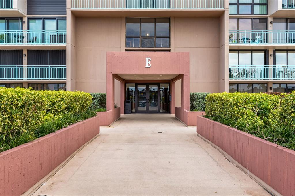 1 Key Capri, Unit 104E Treasure Island, FL 33706 - Photo 3 of 45 a front view of a house with a yard and garage