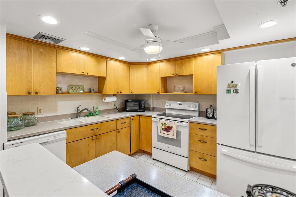 1 Key Capri, Unit 104E Treasure Island, FL 33706 - Photo 6 of 45 a kitchen with a refrigerator a sink and cabinets