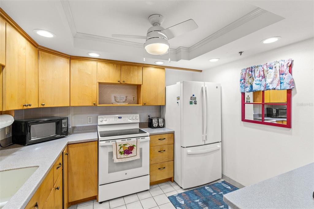 1 Key Capri, Unit 104E Treasure Island, FL 33706 - Photo 7 of 45 a kitchen with a refrigerator and a stove top oven