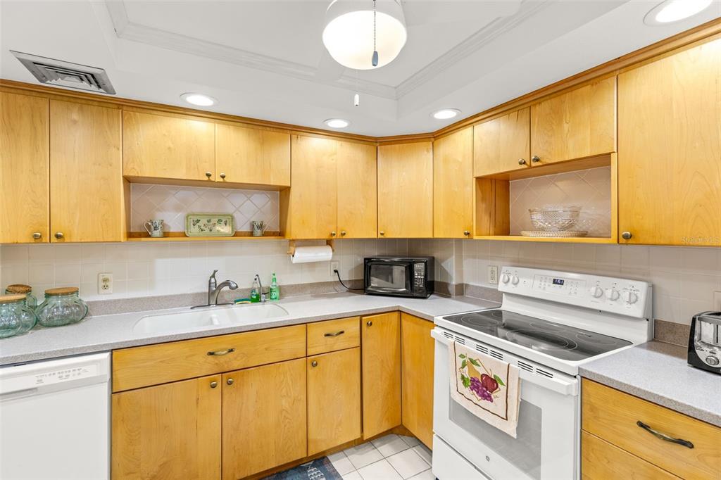 1 Key Capri, Unit 104E Treasure Island, FL 33706 - Photo 8 of 45 a kitchen with a sink a stove and cabinets