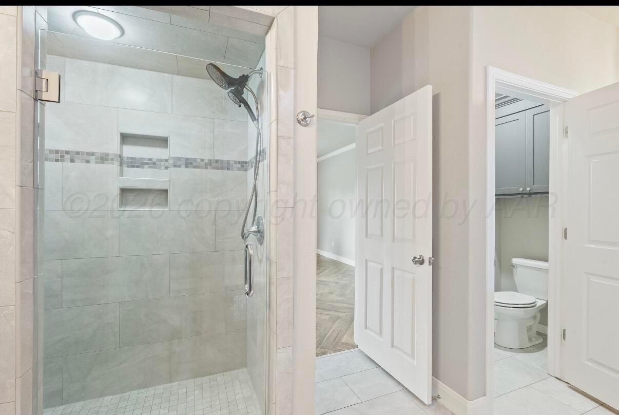 36 Quay Lane Canyon, TX 79015 - Photo 17 of 28 a bathroom with a granite countertop shower mirror and a toilet