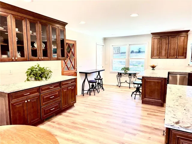 a large kitchen with stainless steel appliances kitchen island granite countertop a sink and cabinets