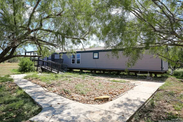 a small yard in front of a house with a large tree