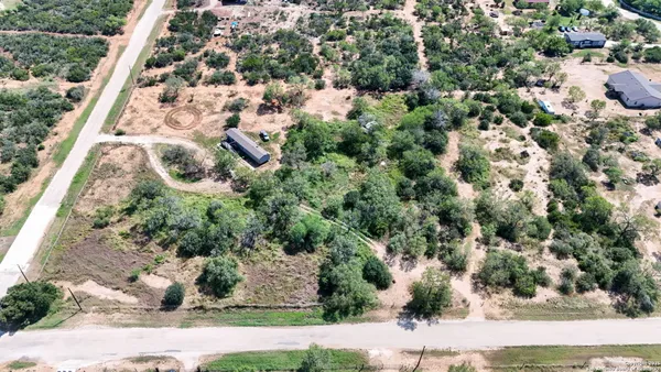 an aerial view of a residential houses with yard