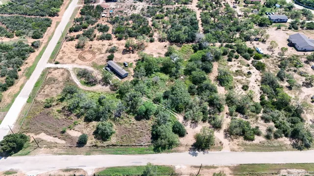 an aerial view of a residential houses with yard
