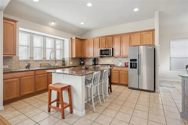 a kitchen with a sink a counter top space cabinets and stainless steel appliances