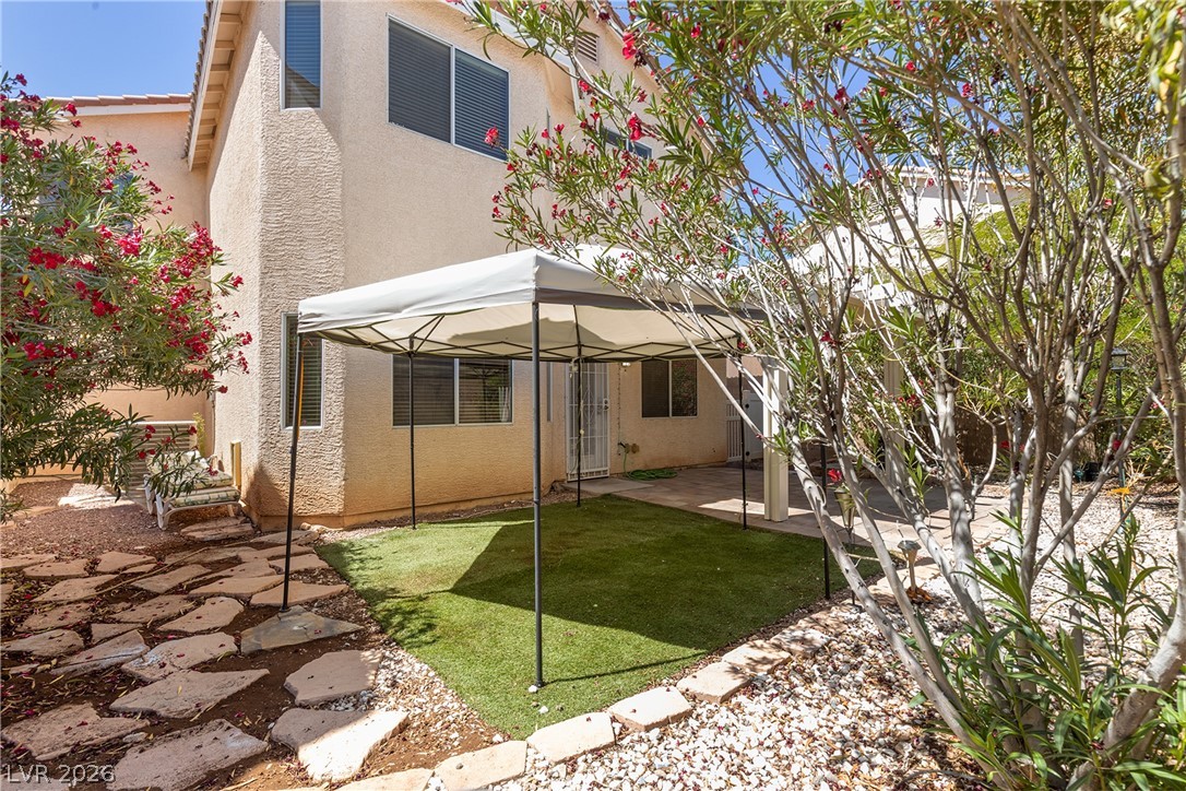 8934 Deep Ridge Court Las Vegas, NV 89178 - Photo 2 of 47 A well-maintained desert landscape frames a cozy outdoor living area with a covered patio.