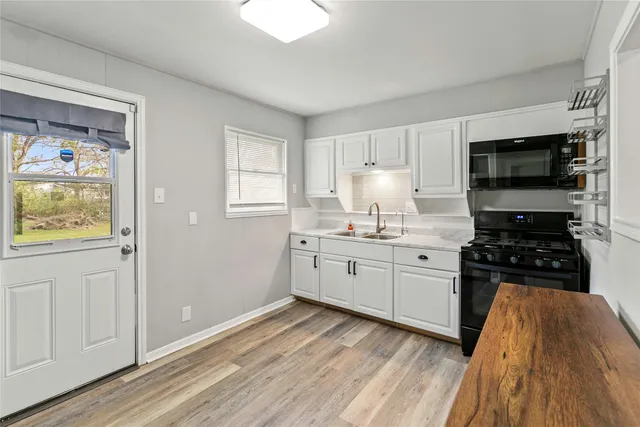 a kitchen with a sink stove top oven and refrigerator
