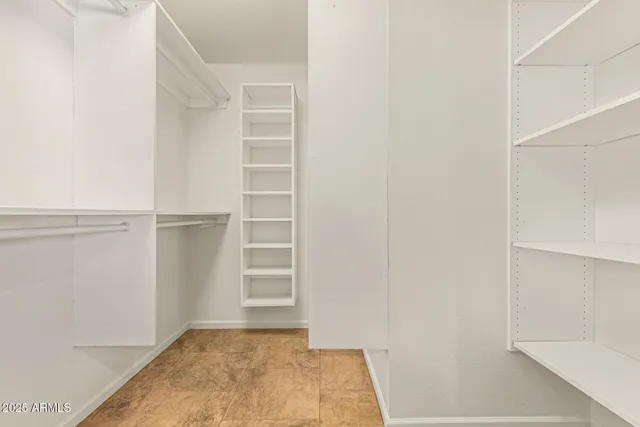 a view of walk in closet with empty racks