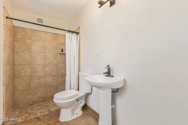 a bathroom with a toilet sink and shower