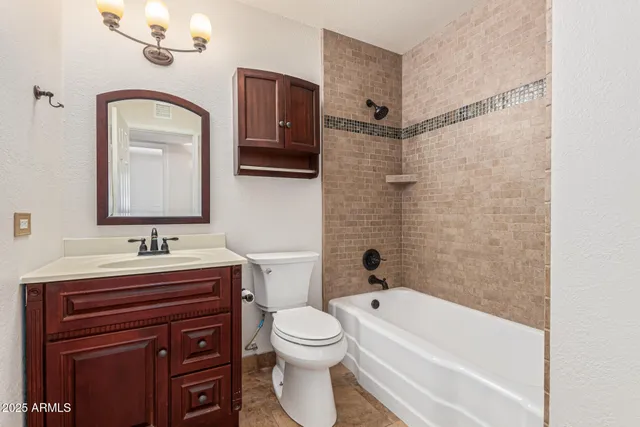 a bathroom with a toilet sink vanity tub and mirror