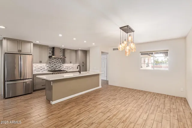 a kitchen with stainless steel appliances granite countertop a refrigerator and a sink