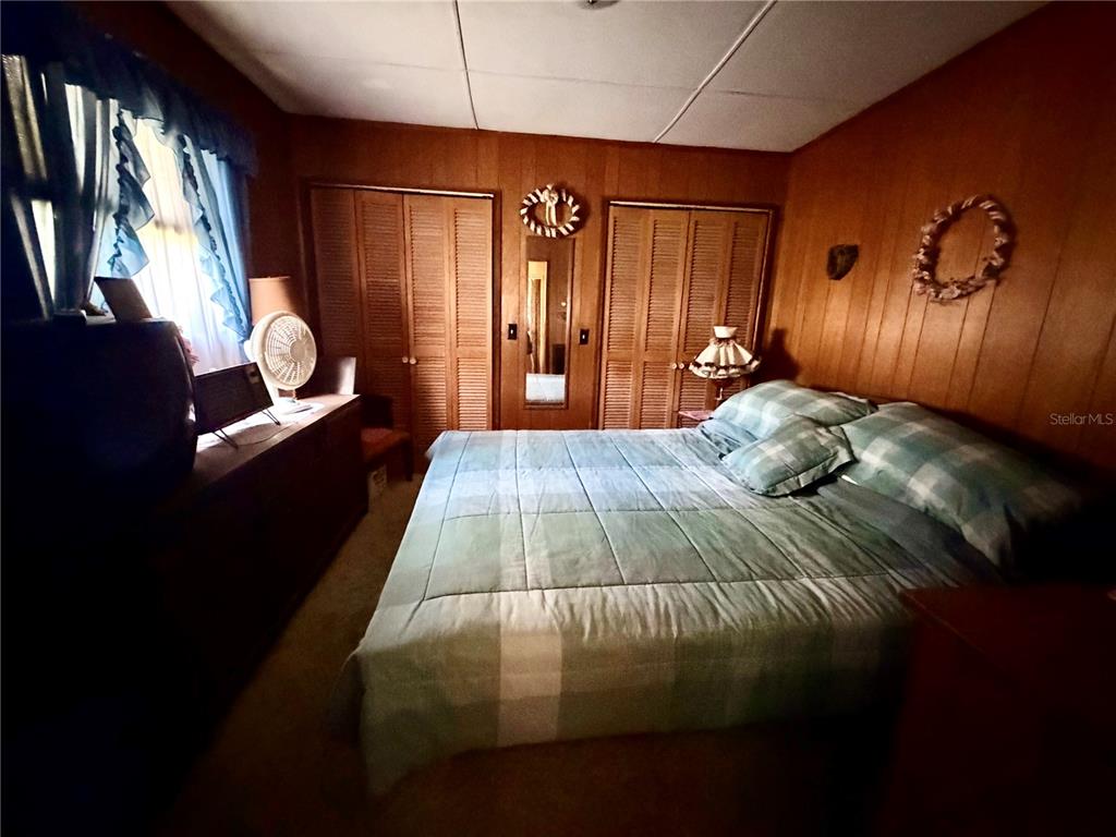 56340 Acorn Road Astor, FL 32102 - Photo 14 of 21 a bed sitting in a bedroom next to a window