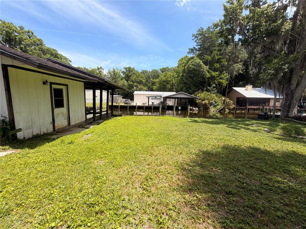 56340 Acorn Road Astor, FL 32102 - Photo 16 of 21 a swimming pool with outdoor seating and yard