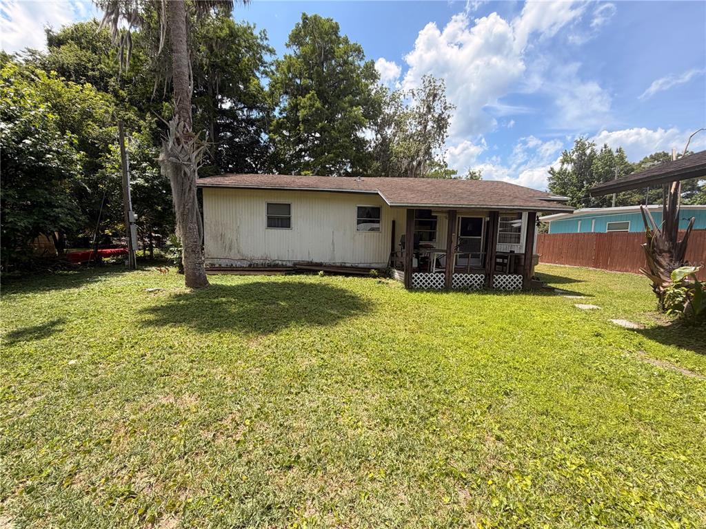 56340 Acorn Road Astor, FL 32102 - Photo 4 of 21 a view of a house with floor to ceiling windows and a yard